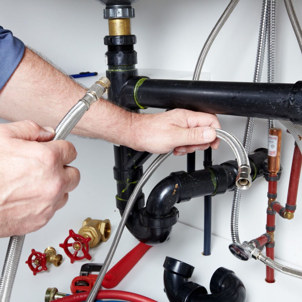 24192014 - hands of professional plumber with a wrench. clogged sink.